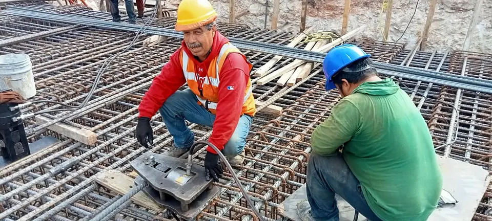 Dos trabajadores prensan un cople en el armado de una losa con el equipo G7K en posición horizontal