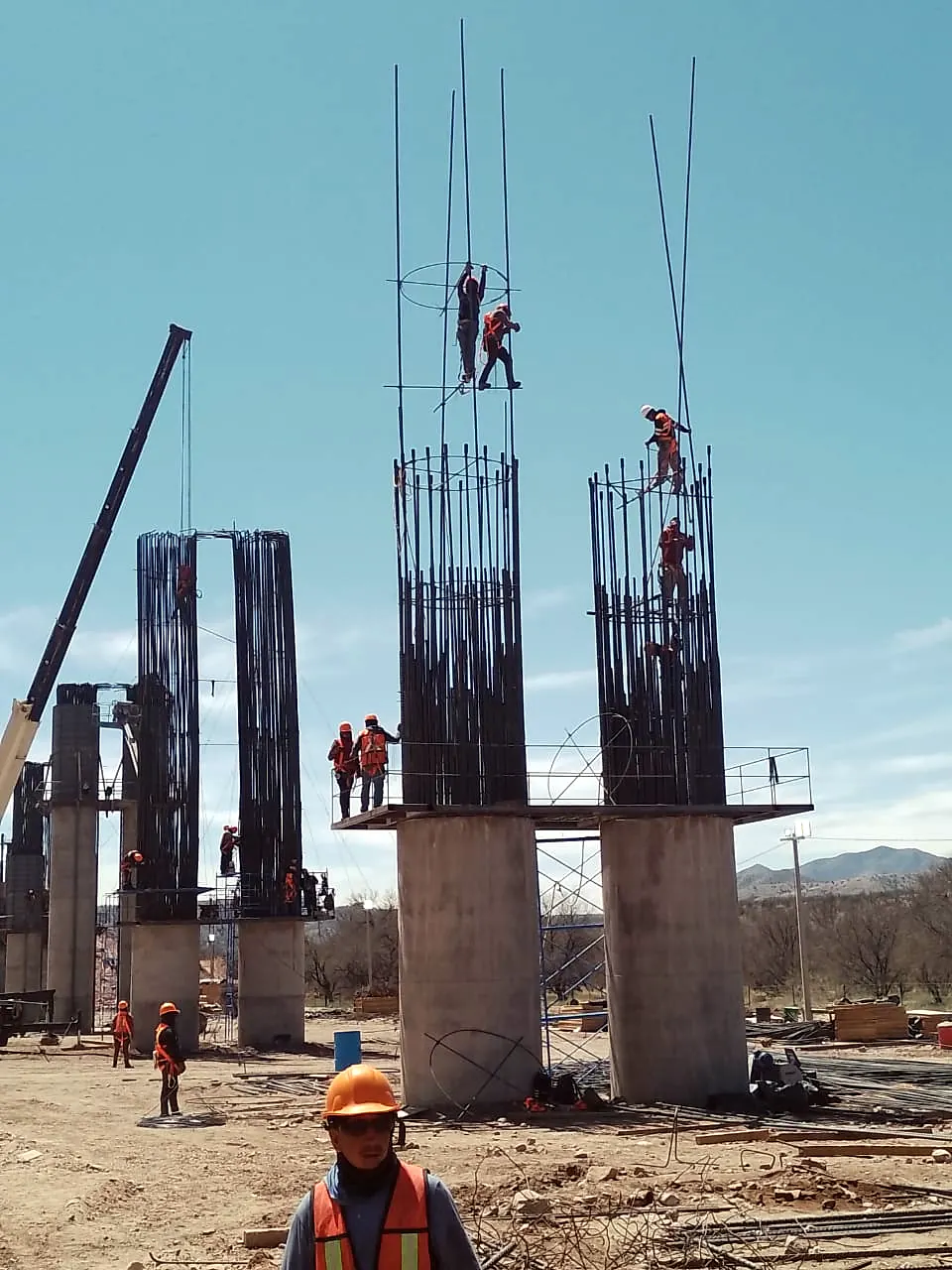 Trabajadores en el armado de columnas de concreto de un puente